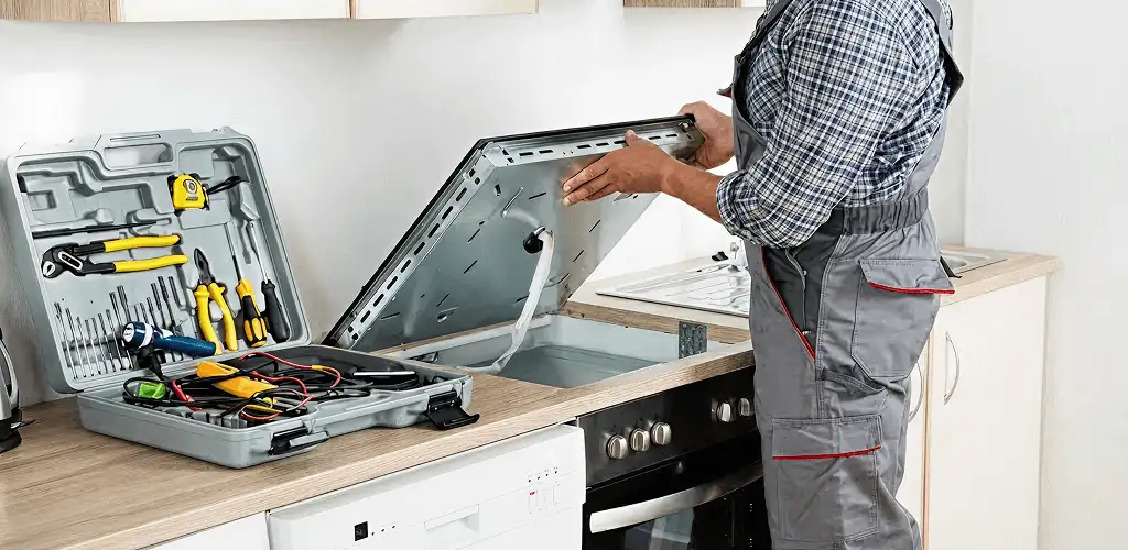 Handyman repairing a cooktop and checking wiring connections in Oklahoma City, OK