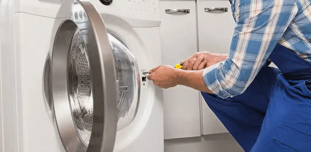 Handyman repairing a clothes dryer and checking electrical connections in Oklahoma City, OK