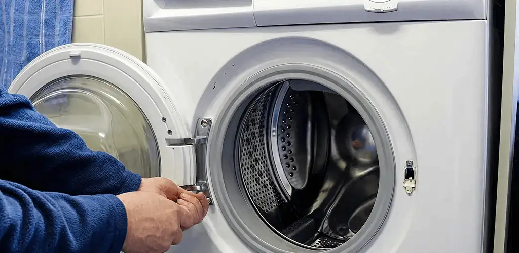 Washing machine repair handyman checking a front-load washer door and latch in Oklahoma City, OK