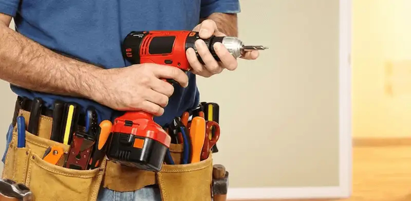 Handyman holding a power drill for home repairs and installations in Oklahoma City, OK