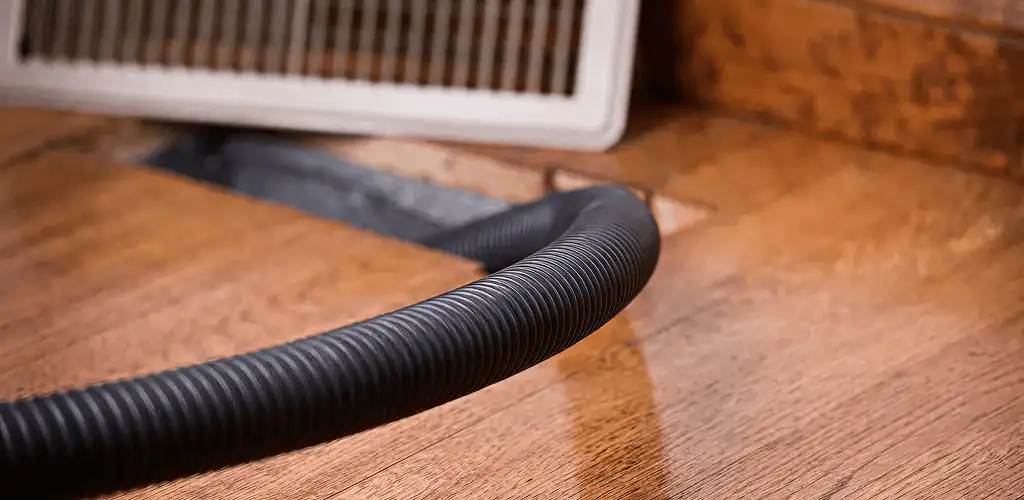 Air duct cleaning hose inserted into a floor vent for ductwork cleaning in Oklahoma City, OK